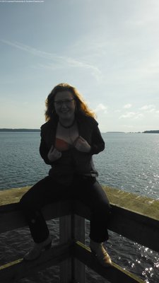 dark blue jeans, orange bra &amp; flashing on a pier.